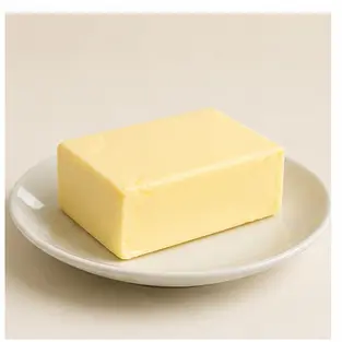 A block of butter on a plate for English food vocabulary learners.