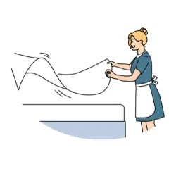 A woman changing a bed sheet