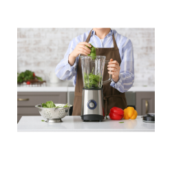 A woman blending fresh spinach