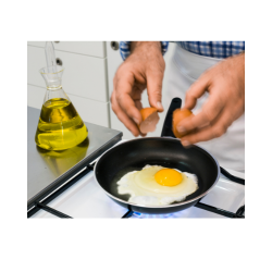 A man frying eggs.