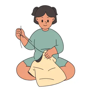 A girl sitting and sewing a tee shirt