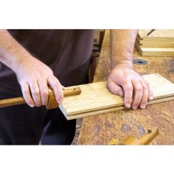 A carpenter using a marking gauge