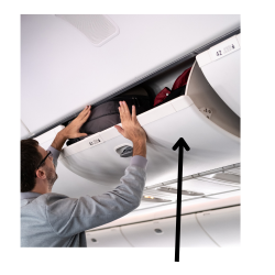 A man putting his luggage in the overhead compartment