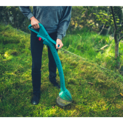 A woman cutting grass with a strimmer