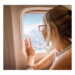 A girl sitting in a plane by the window mrgb30